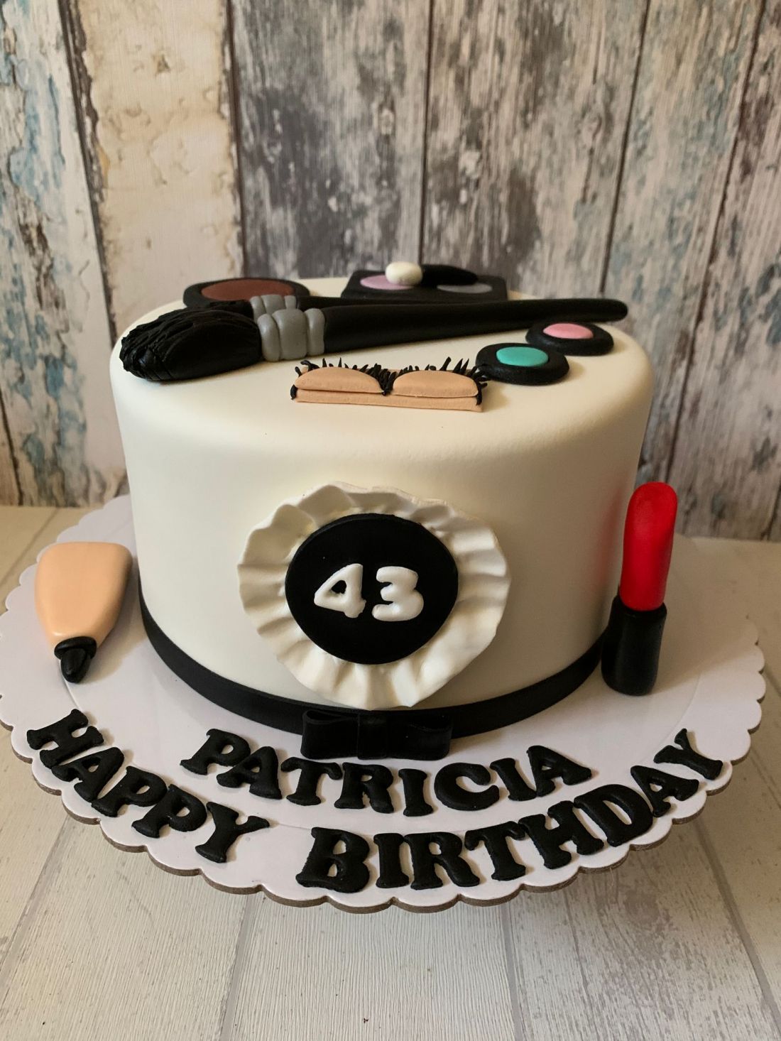 tarta de fondant con pintalabios y brochas de maquillaje