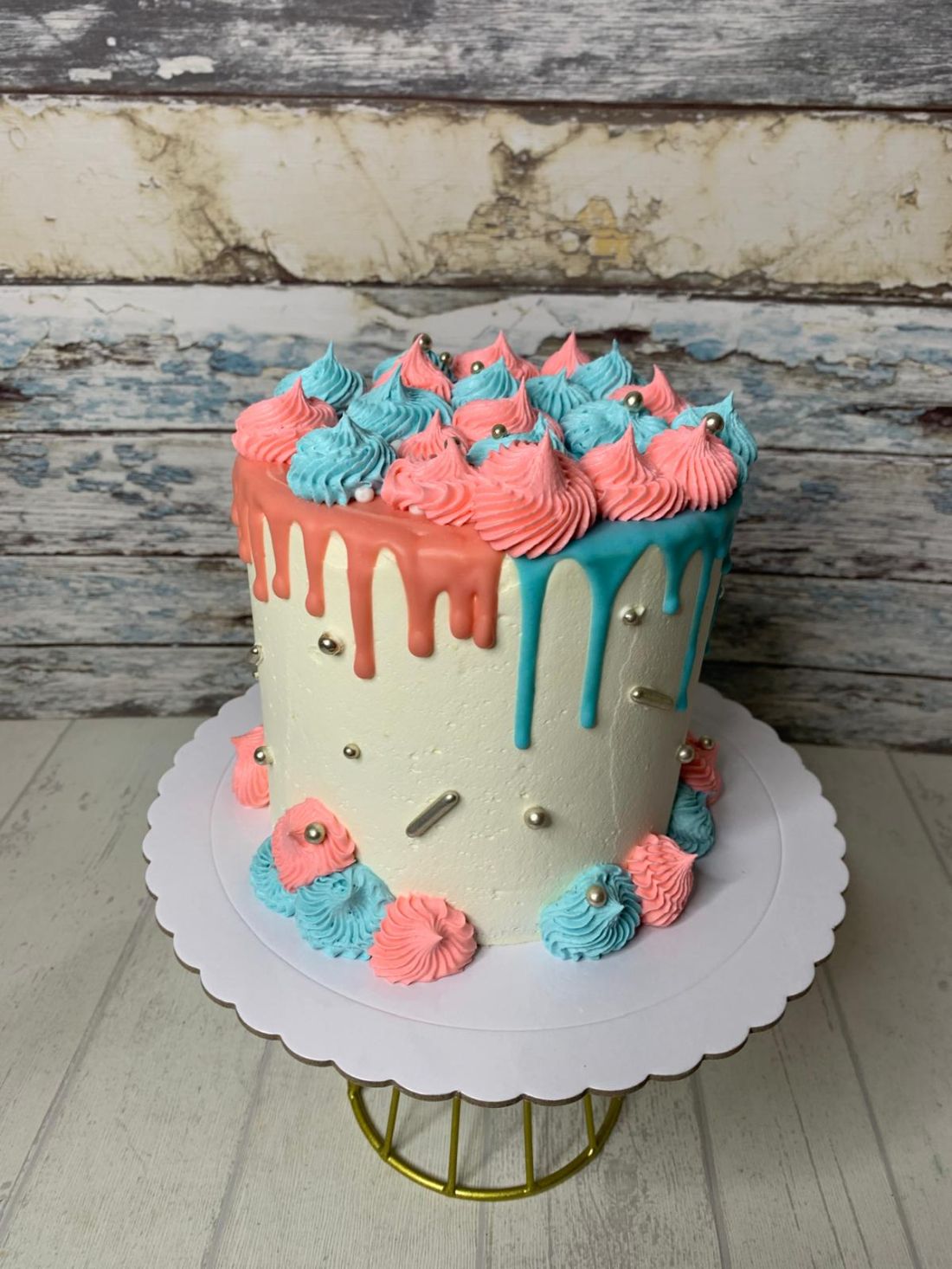 Tarta fondant Drip Cake decorado con crema de mantequilla rosa y azul para revelación de género o baby shower