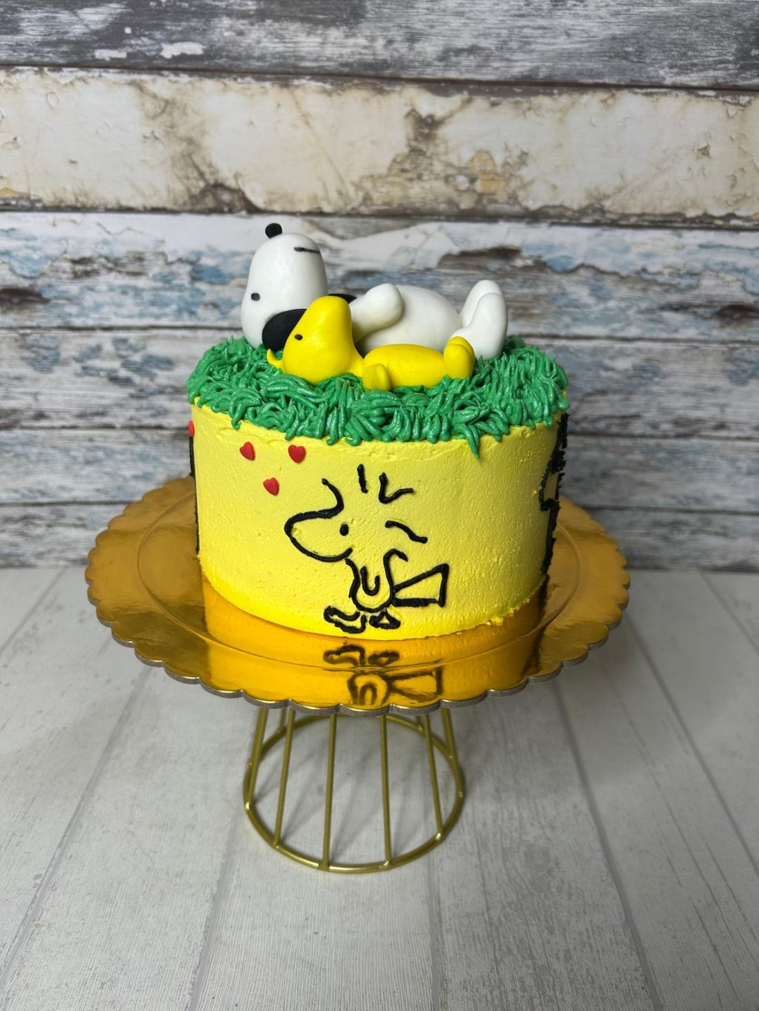 Tarta de cumpleaños temática de Woodstock y Snoopy con figuras de fondant.