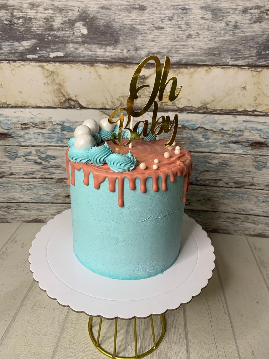 Tarta personalizada para baby shower o revelación de género con diseño drip coral, crema azul y topper Oh Baby